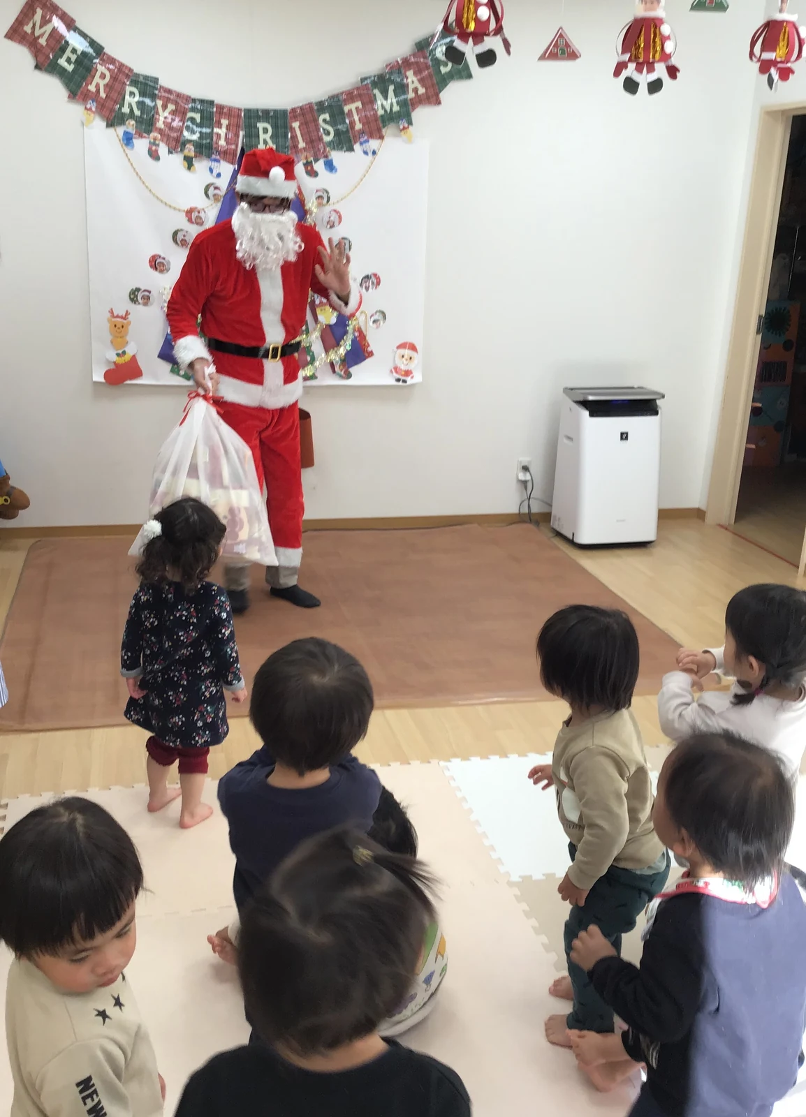 サンタクロースを囲んでクリスマスを楽しむ子どもたち