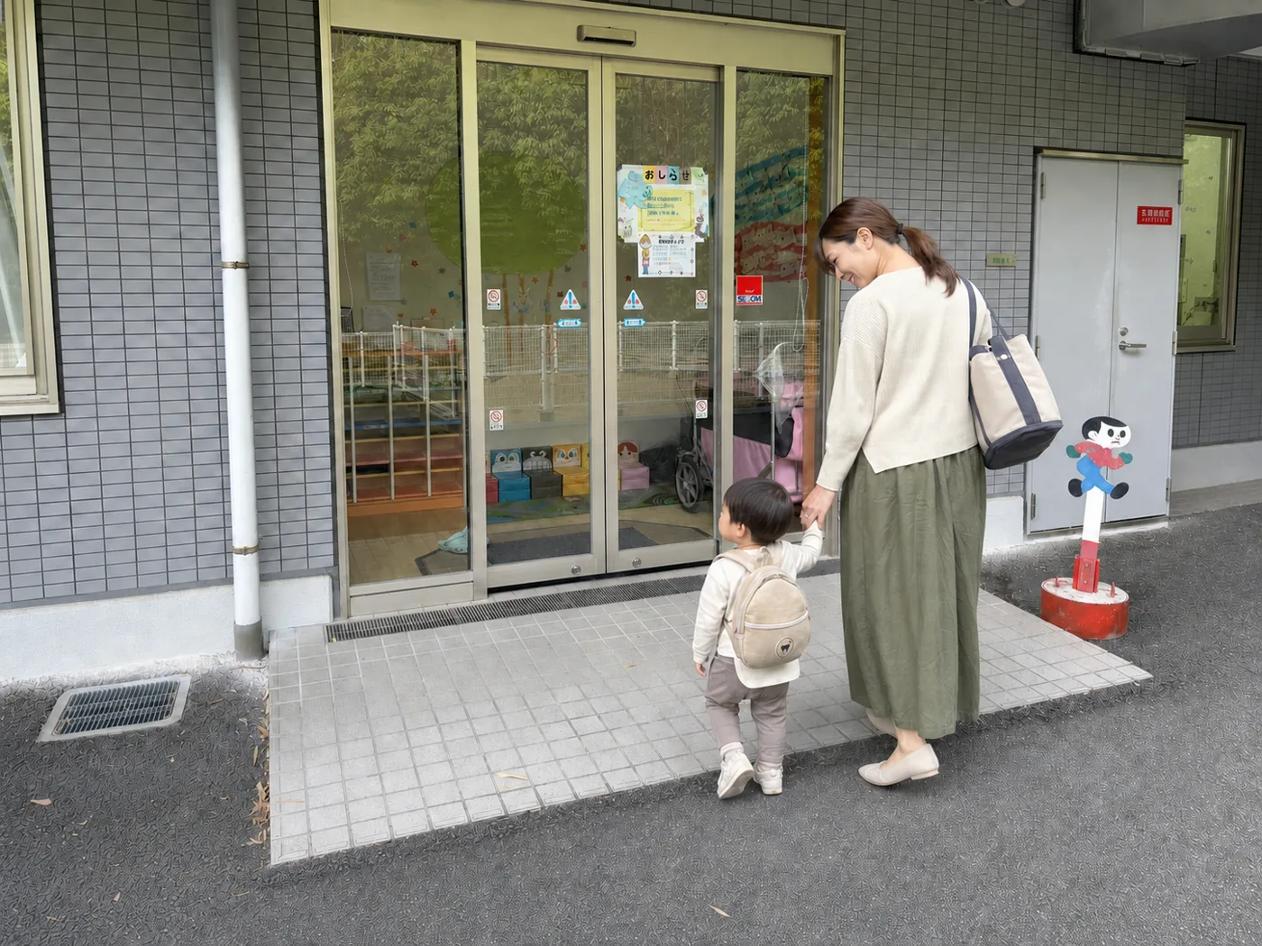 私服で2歳くらいの子どもとおひさまほいくしょへ向かう職員