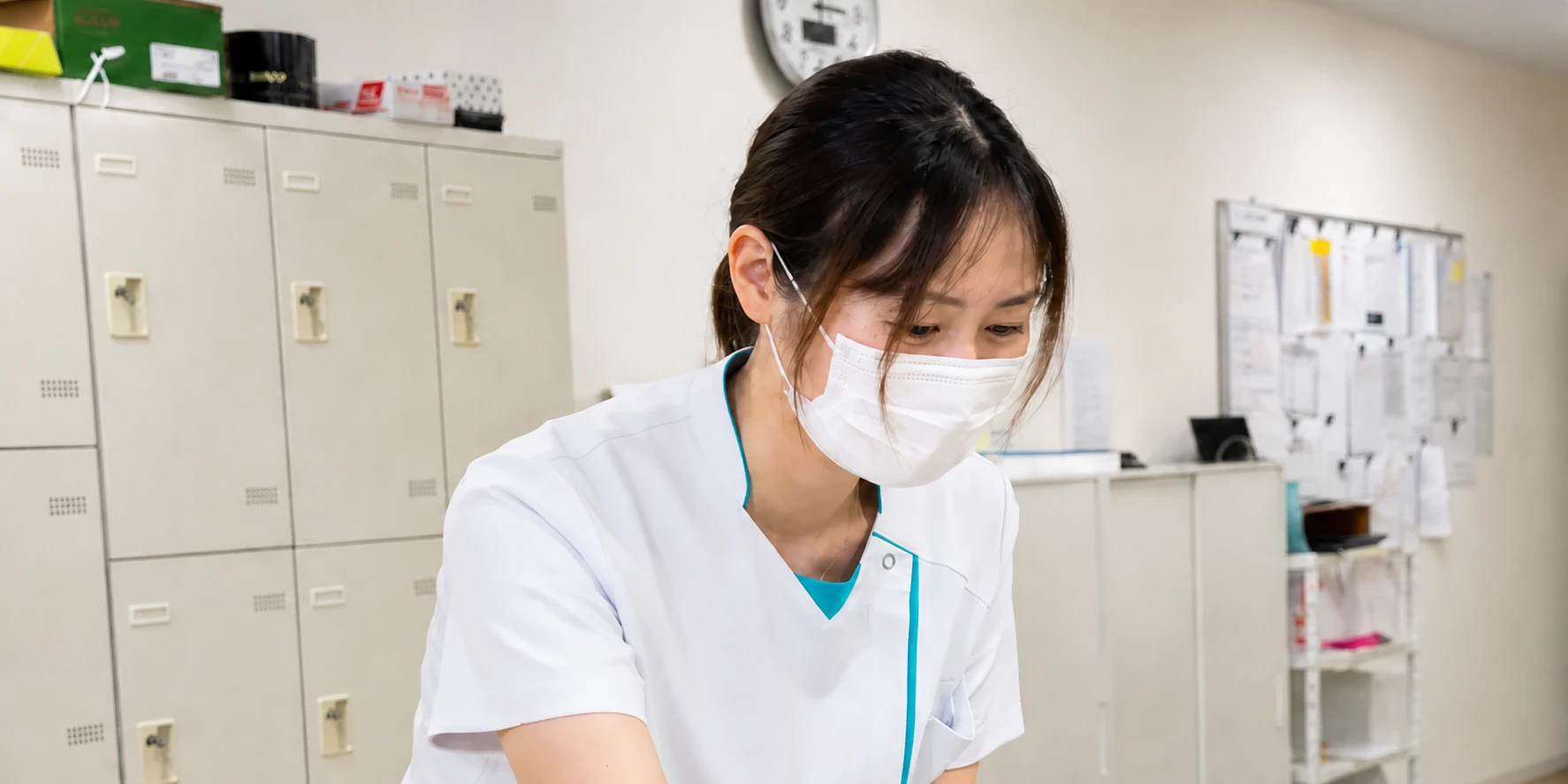 スタッフステーションで記録を確認する看護師
