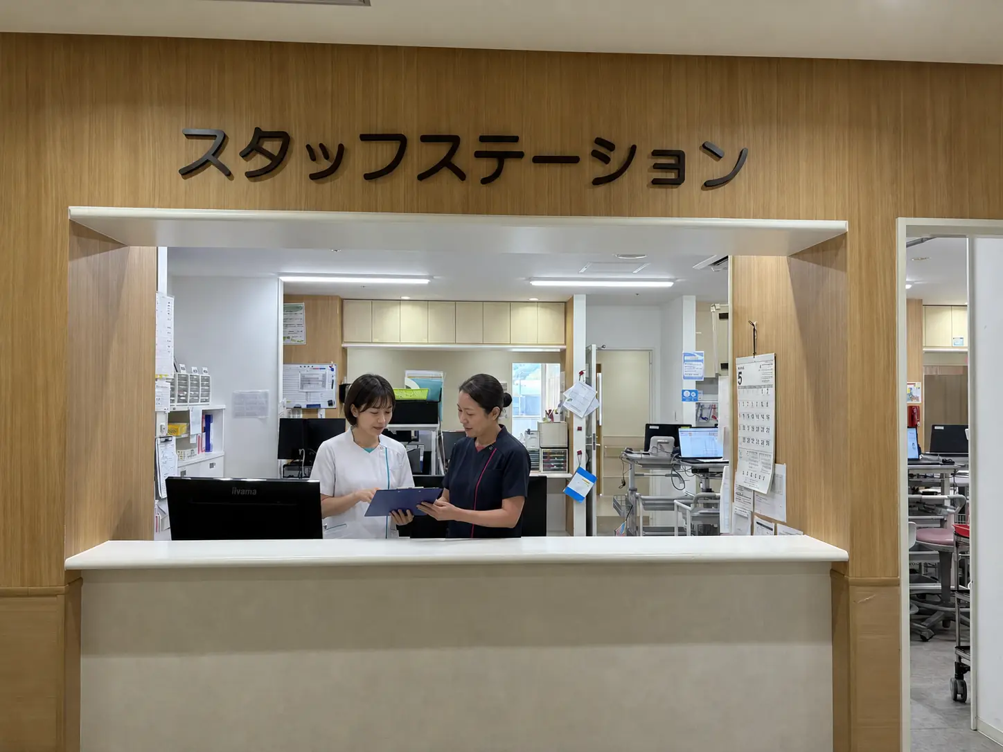 スタッフステーションで確認を行う看護師