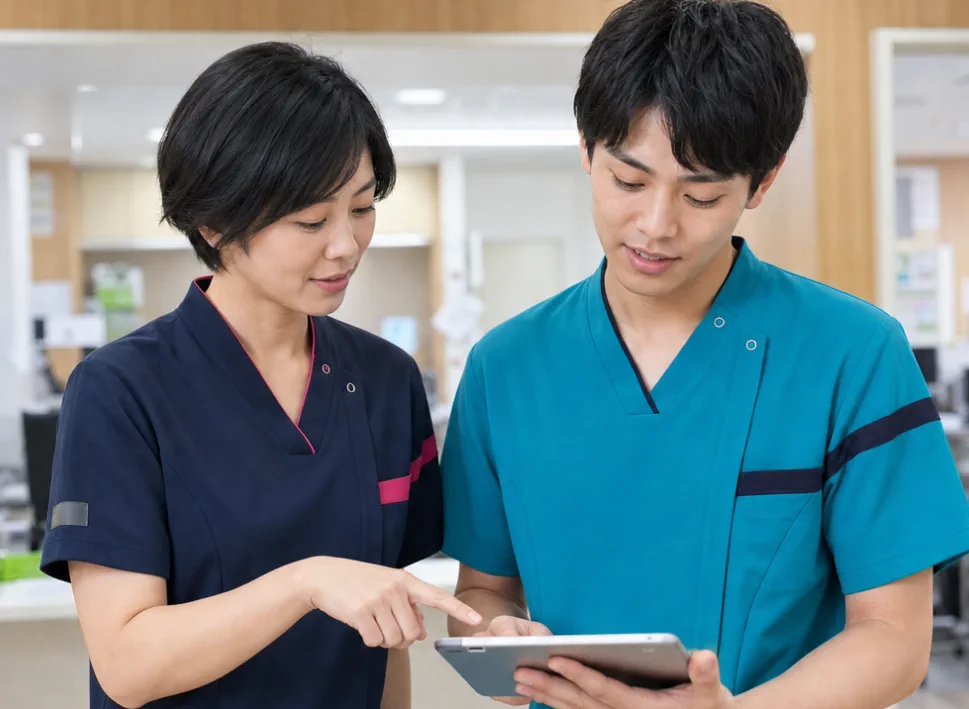 多職種の職員がタブレットを見ながら相談する様子